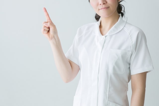 人差し指を立てて説明をする看護師の女性